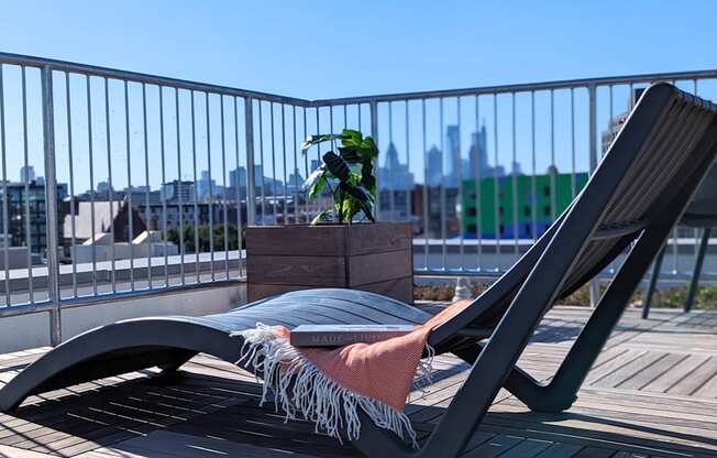 a lounge chair on a balcony with a view of the city