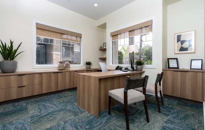 an office with a desk and chairs and a window