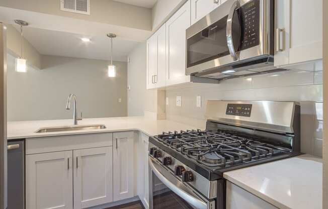 a kitchen with white cabinets and stainless steel appliances