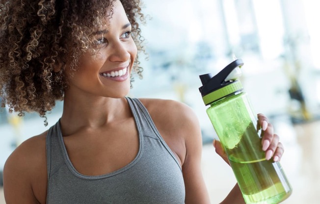 woman working out drinking water