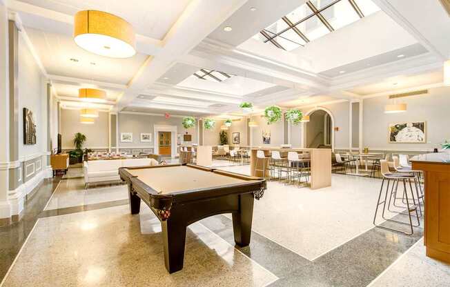 A spacious room with a pool table in the center.