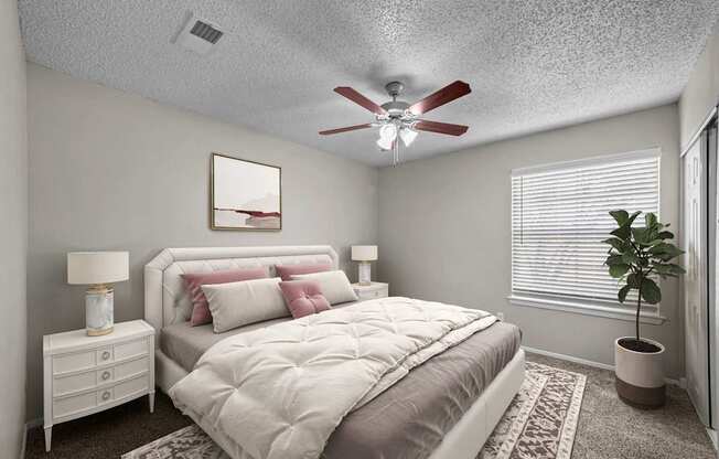 A bedroom with a bed, nightstand, and a ceiling fan.