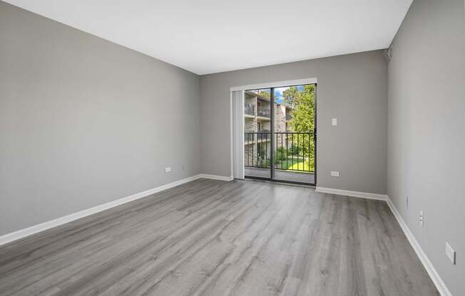 A room with a sliding glass door leading to a balcony.
