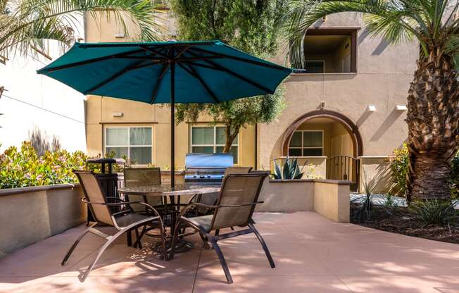 a patio with a table and chairs and an umbrella