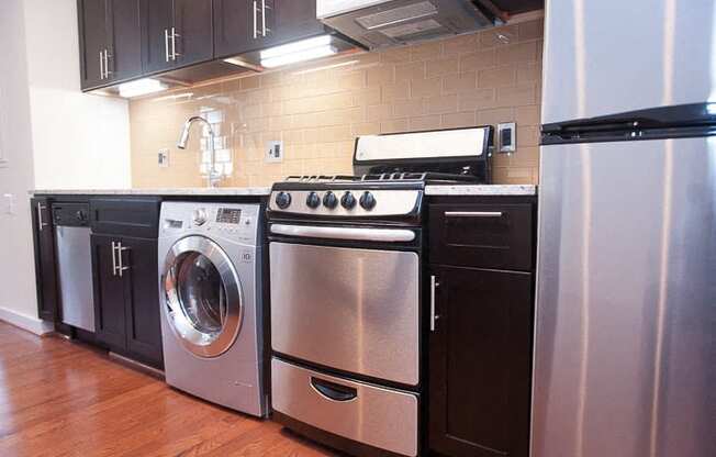 a kitchen with stainless steel appliances and black cabinets