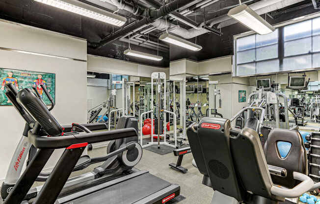 A gym with treadmills, weights, and exercise machines.