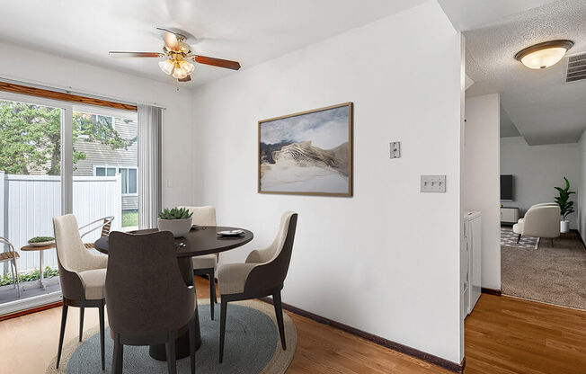 A dining room with a table and chairs.