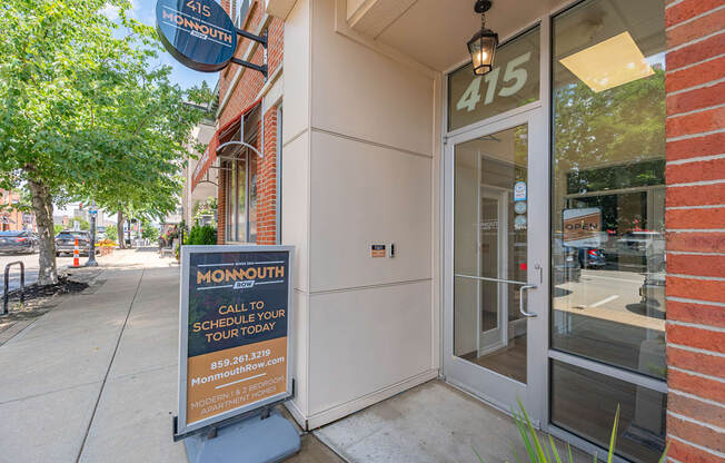 A Monmouth sign is on the sidewalk in front of a building.
