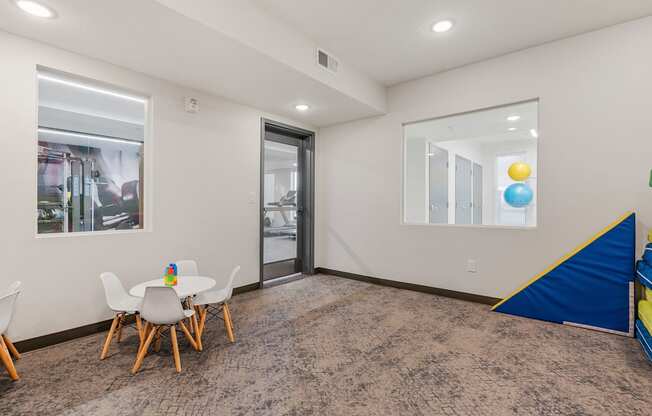 a play room with a table and chairs and a sliding glass door