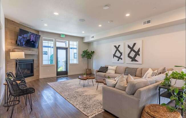 A living room with a grey couch, a television, and a rug at Timberridge Place Apartment Homes, Albany