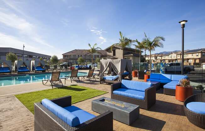 a pool area with lounge chairs and a fire pit