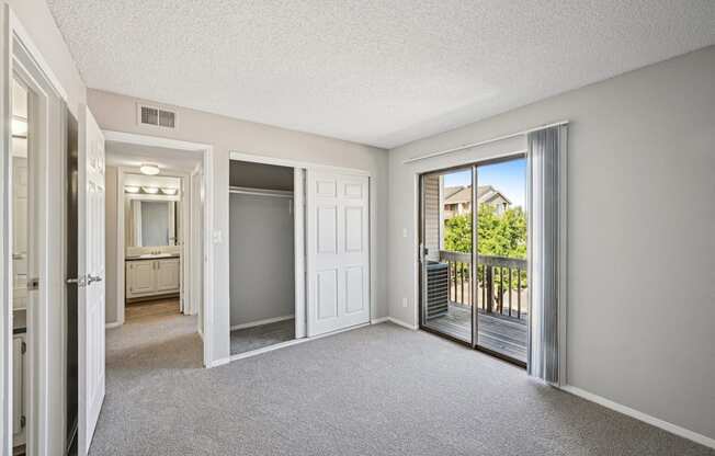 an empty living room with sliding glass doors to a balcony