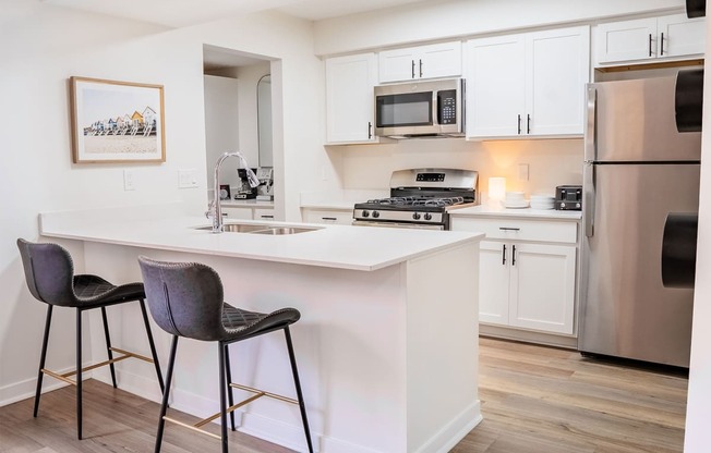 A kitchen with a white countertop and a fridge.