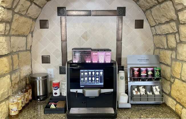 a coffee maker and coffee cups on a counter in a hotel kitchen