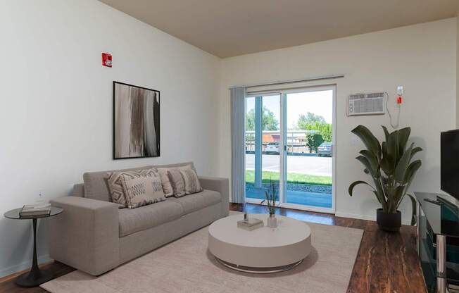 A living room with a couch, a coffee table, and a painting on the wall.