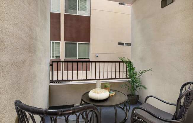 a small balcony with a table and chairs