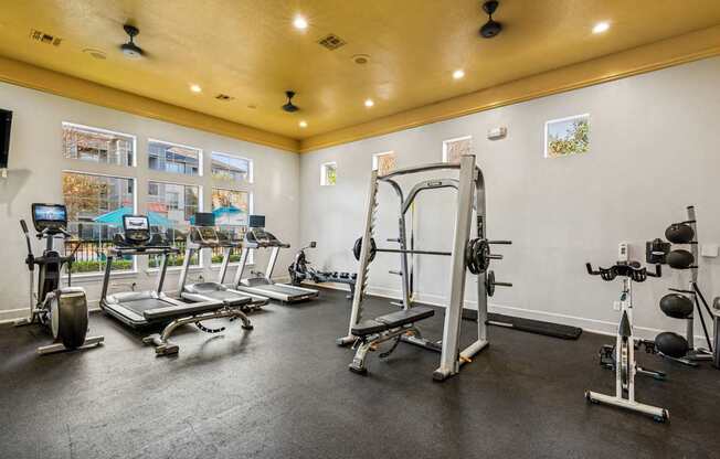 A spacious gym with a variety of equipment including treadmills, weight machines, and exercise bikes.