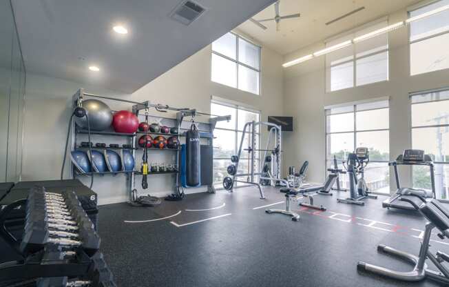 a large fitness room with weights and cardio equipment