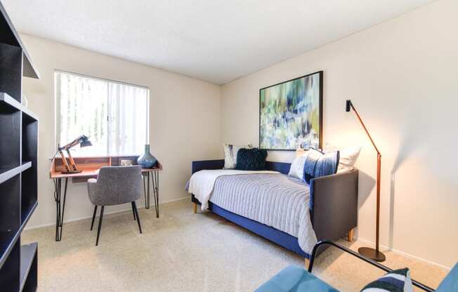 Model Home bedroom with a bed and a desk with a chair at Renaissance Park Apartments, Davis