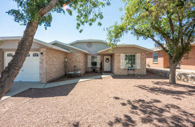 A house with a driveway and trees in front.