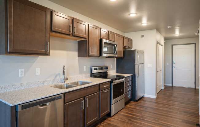 a kitchen with stainless steel appliances and a granite counter top. Fargo, ND 29 West Apartments