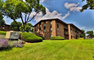 A building with a sign that says "Willisville Apartments" in front of it.