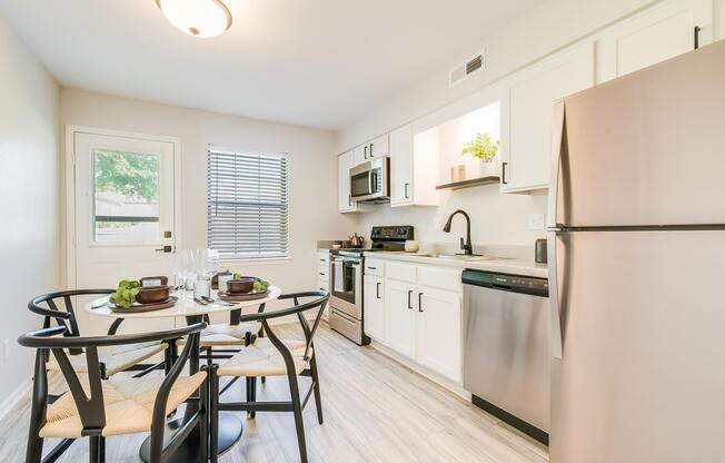 Kitchen table and stainless steel appliances at The Arbor in Blue Springs, MO