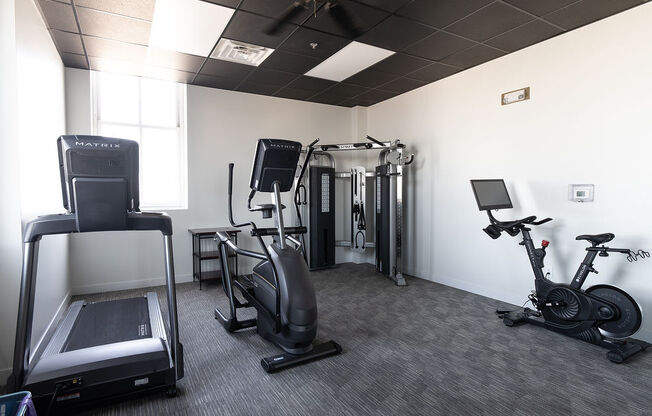 a gym with various machines and weights in a room