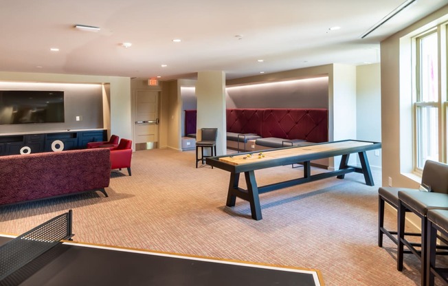 a games room with a ping pong table and a television