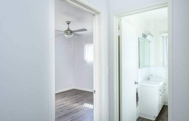 an empty bathroom with a mirror and a ceiling fan