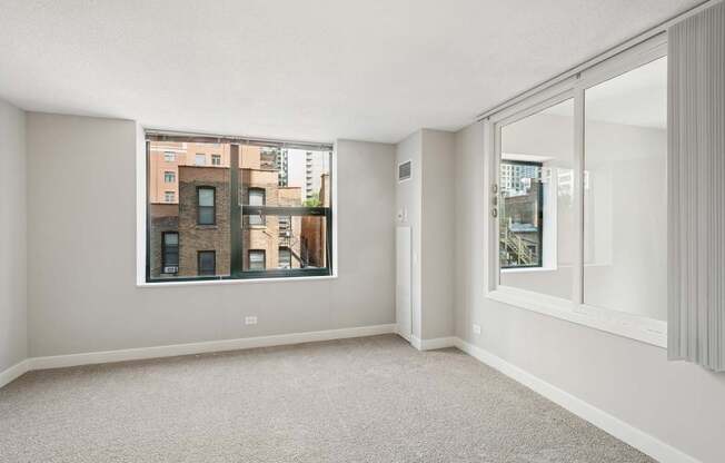 A large, empty room with a view of a cityscape through a window.