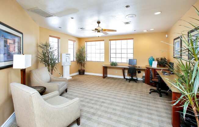 a living room with couches and chairs and a desk with a computer