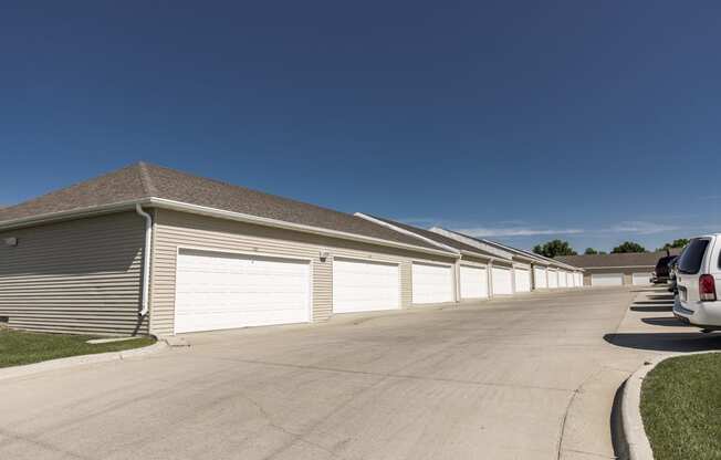 a row of garages with cars parked in front of them. Bismarck, ND Sunset Ridge Apartments