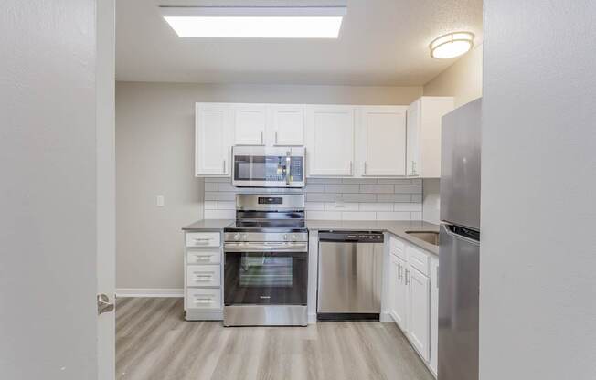 A kitchen with white cabinets and stainless steel appliances.