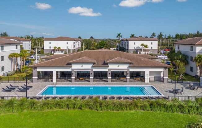 a house with a swimming pool in front of some buildings