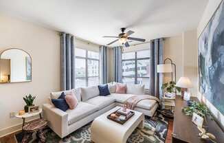 a living room with a couch and a ceiling fan