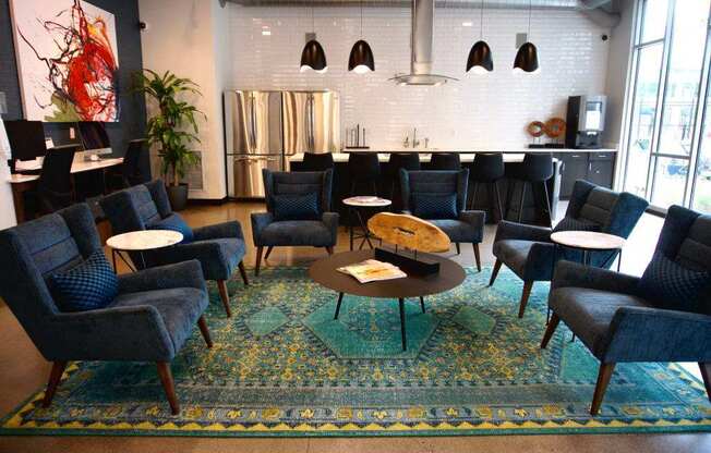 A living room with blue chairs and a rug.