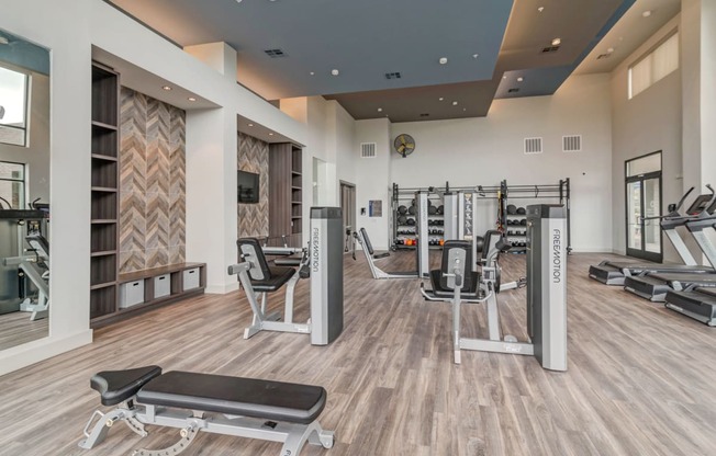 a gym with cardio equipment and weights on the floor