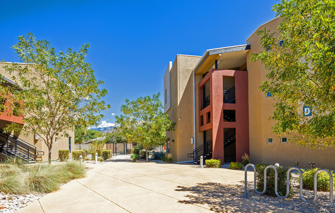 a building with a sidewalk and trees in front of it