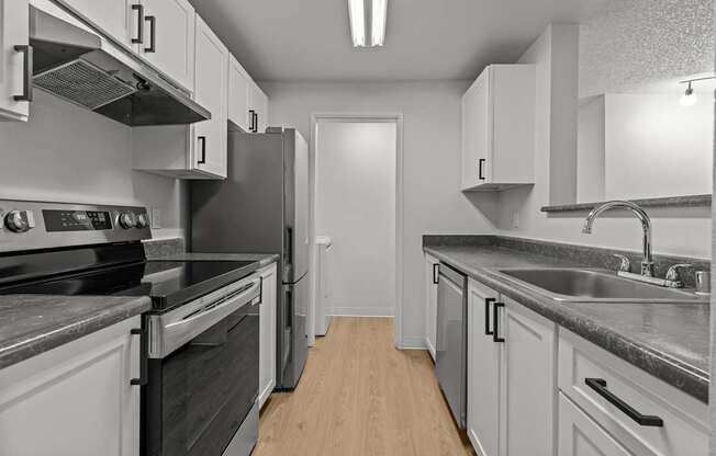 A kitchen with white cabinets and stainless steel appliances.