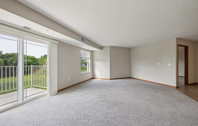 an empty living room with sliding glass doors to a balcony