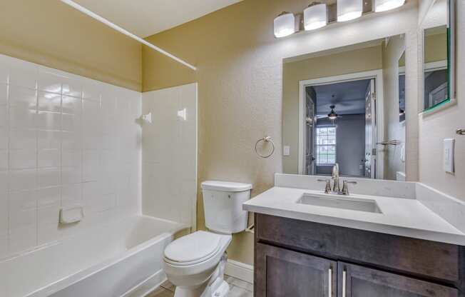 a bathroom with a toilet sink and shower and a mirror