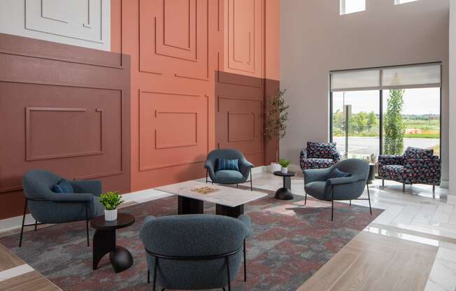 a living room with chairs and tables and a window at The Edison at Maple Grove, Maple Grove, MN