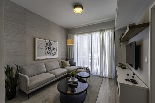 a living room with a couch and a table the gym  at a residential apartment community Resia in Decatur GA