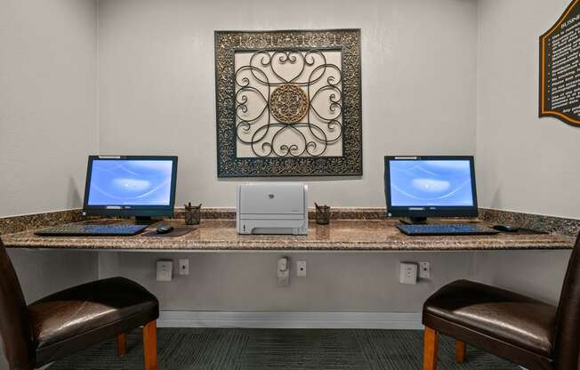 a desk with three computers on it