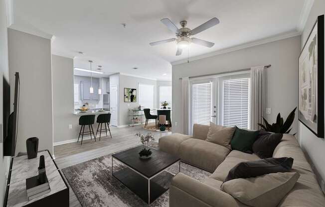 A living room with a couch, a coffee table, and a ceiling fan.