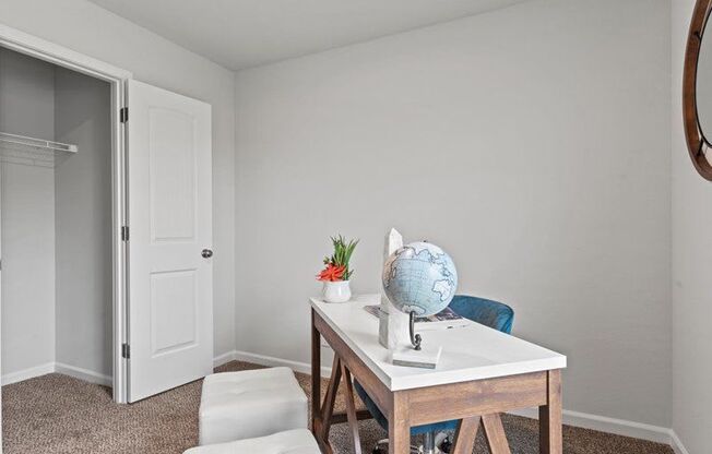 a home office with a desk and chair and a white door