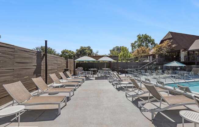 A poolside area with sun loungers and a pool.