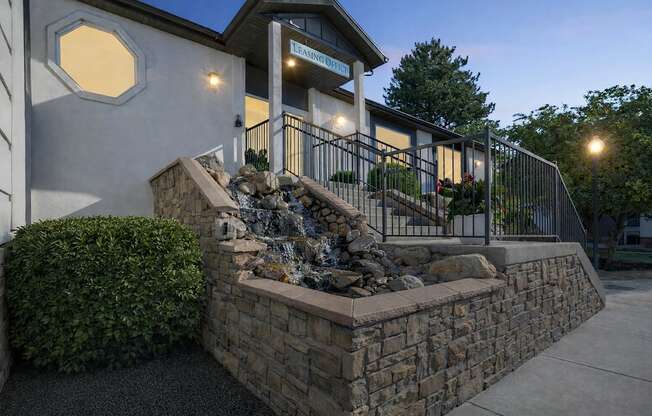 A house with a stone wall and a fence.