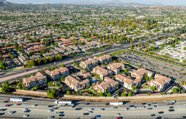 an aerial view of an intersection with cars and houses